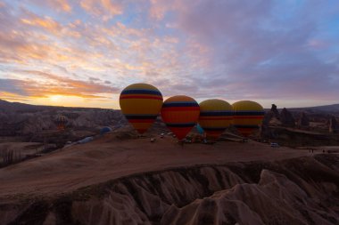 Türkiye 'nin Kapadokya kentindeki sıradışı kayalık manzaraya yüzeysel bir bakış açısı. Kapadokya 'daki peri bacalarıyla mavi gökyüzünde renkli sıcak hava balonları uçuyor..