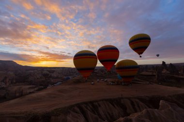Türkiye 'nin Kapadokya kentindeki sıradışı kayalık manzaraya yüzeysel bir bakış açısı. Kapadokya 'daki peri bacalarıyla mavi gökyüzünde renkli sıcak hava balonları uçuyor..