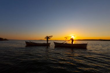 Balıkçılar denize balık ağı atıyorlar.