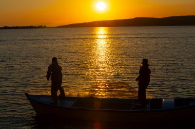 Balıkçılar denize balık ağı atıyorlar.