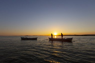 Balıkçılar denize balık ağı atıyorlar.