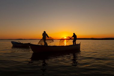 Balıkçılar denize balık ağı atıyorlar.