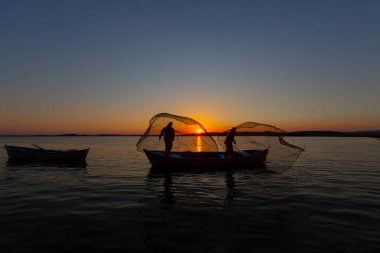 Balıkçılar denize balık ağı atıyorlar.