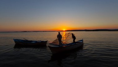 Balıkçılar denize balık ağı atıyorlar.