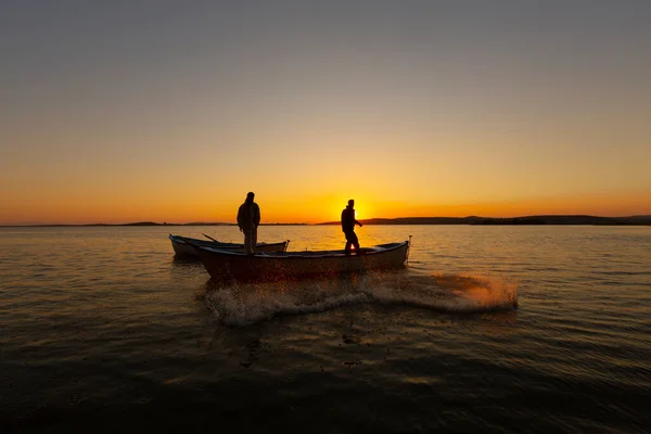 Fishermen throwing fishing net into the sea