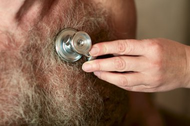 Phonendoscope - steteskop kıllı erkek göğüs üzerinde. Doktor kalp için dinler