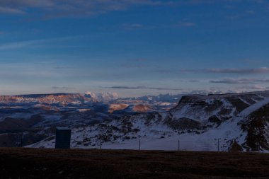 Geçici bir tuvalet, dağlara karşı dikenli tel örgü. Bermamyt platosundan görüntü.
