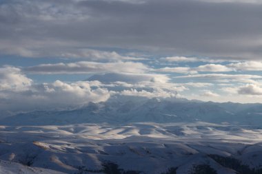 Elbrus kışın gün batımında bulutlarda