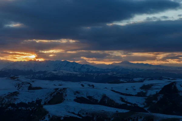 Batan güneş bulutlar aracılığıyla dağ sırasını aydınlatır. Bermamyt platosundan görüntü. Karachay-Cêess Cumhuriyeti, Rusya