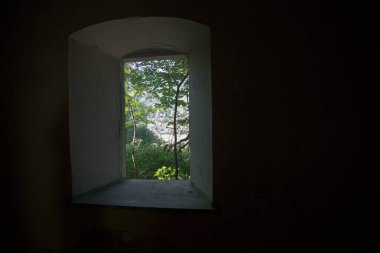 Kalın bir taş duvarda açılan bir pencere.