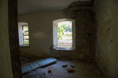 Kalın taş duvarda kırık bir pencere.