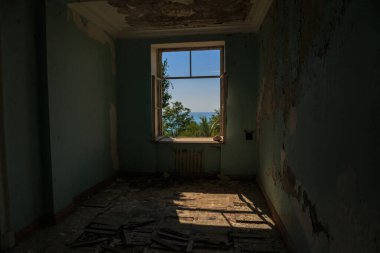 Terk edilmiş bir evde deniz manzaralı pencere