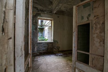 Terk edilmiş bir evde açık bir pencere.