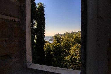 Terk edilmiş bir evde kıyı manzaralı bir pencere.