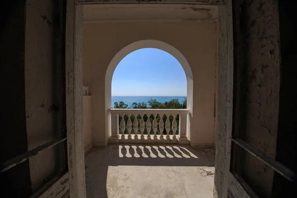 Terk edilmiş bir evde deniz manzaralı pencere