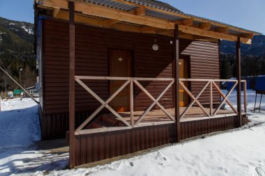 Kışın dağlarda bir turist evinin verandası.