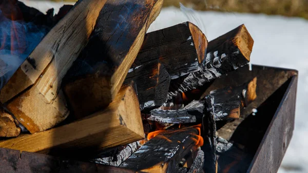 Büyük doğranmış kütüklerin ızgarasında yangın.