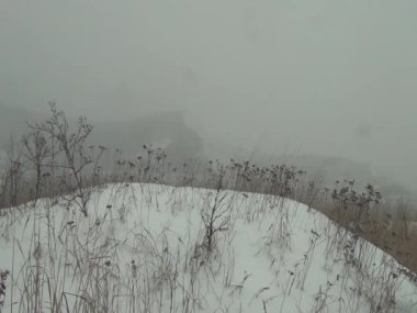 Kar fırtınasında, yağan karların arasında, sisin içindeki dağın hatlarını görebilirsin.