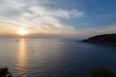 Gün batımında yelkenleri indirilmiş birkaç gemi.