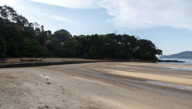 Sakin, sığ bir nehir kumlu bir sahilden denize akar.. 