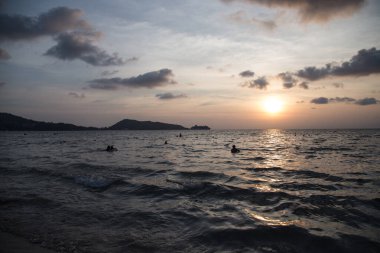 İnsanlar akşam denizinde yıkanır. 