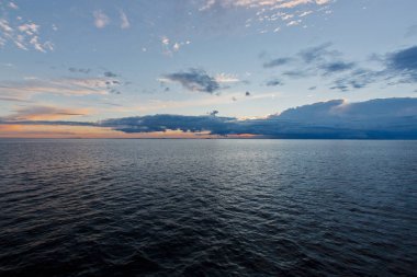 Sakin deniz, renkli bulutlarda gün batımı gökyüzü