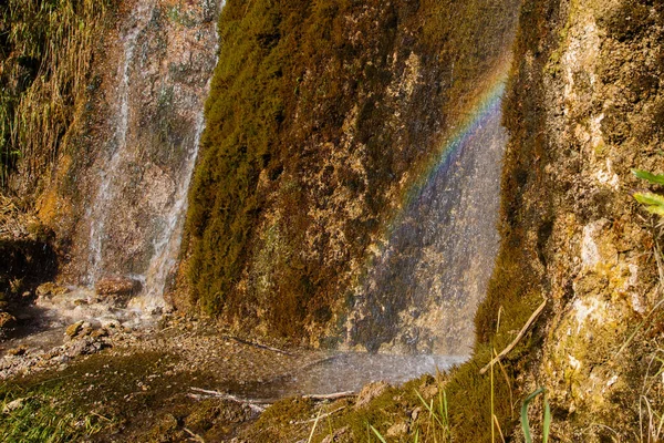 Ett Litet Vattenfall Rinner Nerför Mossiga Klipporna Regnbåge Solens Strålar — Stockfoto