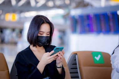 Havaalanında akıllı telefon kullanan Asyalı kadınlar