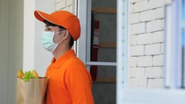 Teslimat işçileri Coronavirüs enfeksiyonunu önlemek için müşterilerine ürünler getiriyorlar.