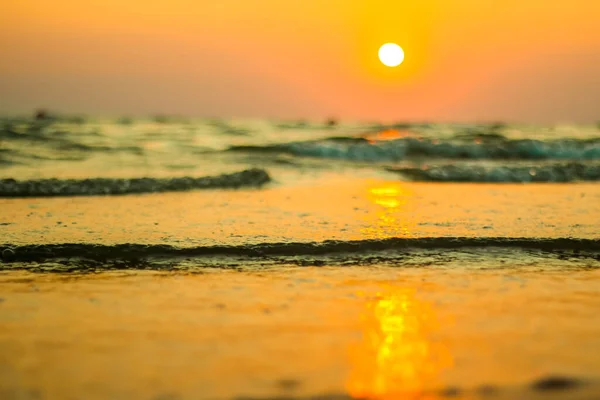 Wet sea sand on beach against background beautiful golden sunset. Close up sea sand on shore ocean during sunset.Landscape sunset sea coast. Golden wet sand sand on beach on a sunset background. — Stock Photo, Image