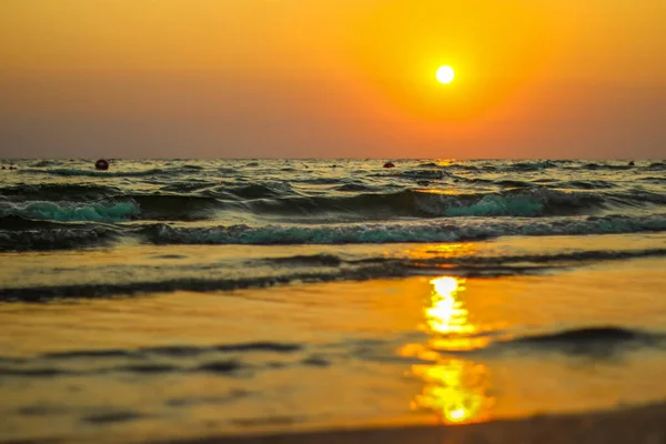 Sable de mer humide sur la plage sur fond beau coucher de soleil doré. Fermer sable marin sur le rivage océan pendant le coucher du soleil.Paysage coucher du soleil côte de la mer. sable humide doré sur la plage sur un fond de coucher de soleil. — Photo