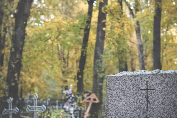 Grafsteen met een traditioneel orthodox kruis op de herfstbegraafplaats — Stockfoto