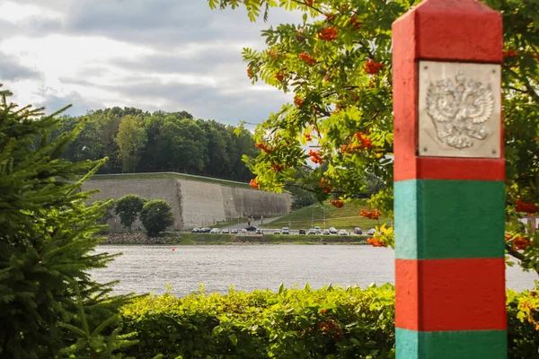 Rusya arması olan kırmızı-yeşil çizgili sınır karakolu. Çift başlı kartal. Narva Nehri. Kenarlık denetimi