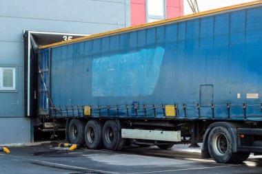 Kamyonlar büyük bir dağıtım deposunda yükleme yaparken. lojistik ihracat ve ulaşım sektörü geçmişi