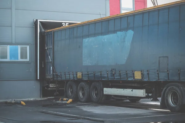Vrachtwagens tijdens het laden in een groot magazijn. Invoer export logistiek en transport — Stockfoto