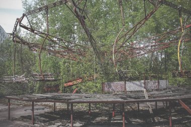 Pripyat 'ın hayalet kasabasında eski bir atlıkarınca. Terk edilmiş şehir ağaçlarla kaplanmış.