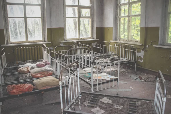 Edificio de jardín de infantes vacío. Cunas dispuestas en desorden. Edificio abandonado en Pripyat — Foto de Stock