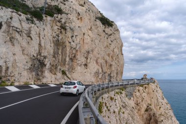 Varigotti, İtalya - 10 Ekim 2020: Liguria, İtalya kıyı şeridi boyunca bir uçurum kenarında ve deniz kıyısında giden araba görüntüsü