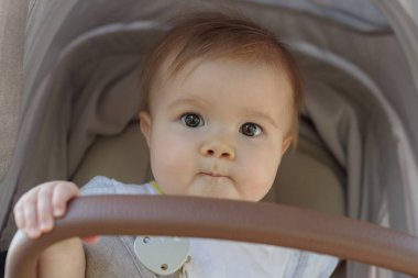 Bebek arabasıyla gezen sevimli kızın yakın çekimi.