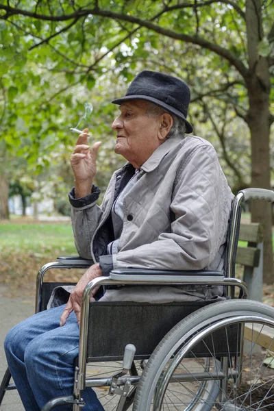 Een Oudere Man Een Rolstoel Rookt Een Sigaret Buiten — Stockfoto