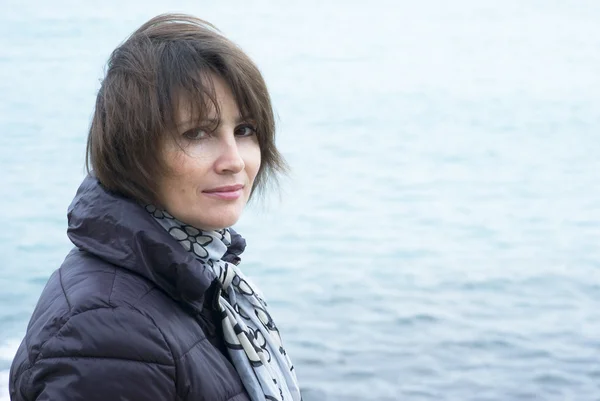 Mujer de pie en condiciones de viento frente al mar — Foto de Stock