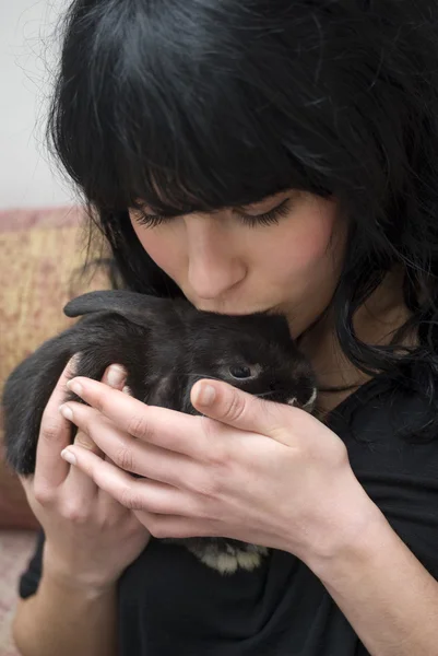 Young woman caressing her pet rabbit at home — Stock Photo, Image