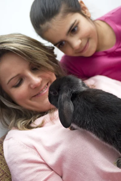 Mujer acariciando a su conejo mascota en casa — Foto de Stock