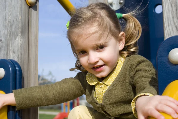 Young girl on slide in playground — Stock Photo, Image