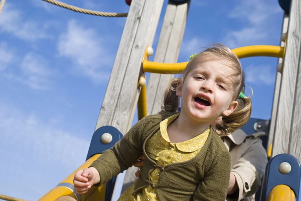 Young girl on slide in playground — Stock Photo, Image