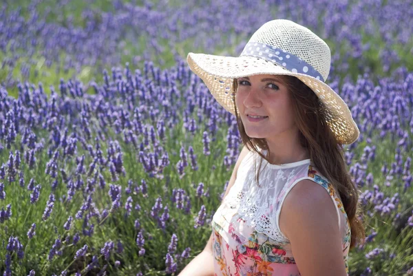 Jonge vrouw met hoed terzake lavendel — Stockfoto