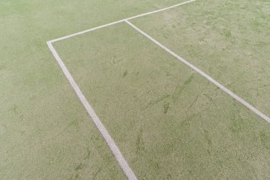 Açık spor sahasında beyaz çizgili suni yeşil çim.