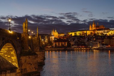 Prag Kalesi ve Charles Köprüsü 'nün bir sonbahar günü, gün batımından önce kapanması.