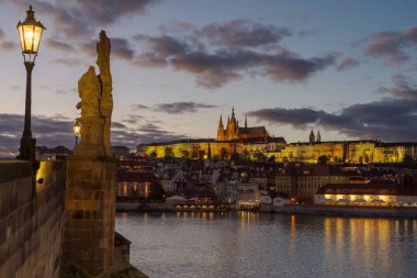 Prag Kalesi ve Charles Köprüsü 'nün bir sonbahar günü, gün batımından önce kapanması.