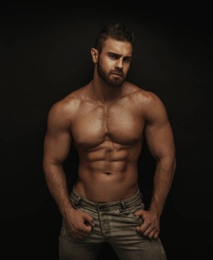 Koyu arkaplanda duran fitness erkek modeli